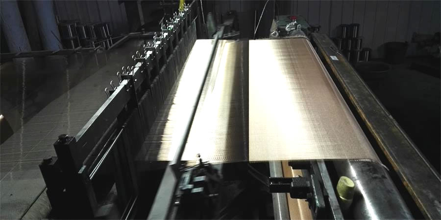 The machine is weaving a roll of copper mesh with fine wire diameter.