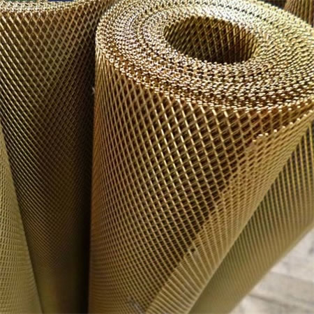 A roll of expanded brass mesh on the ground.