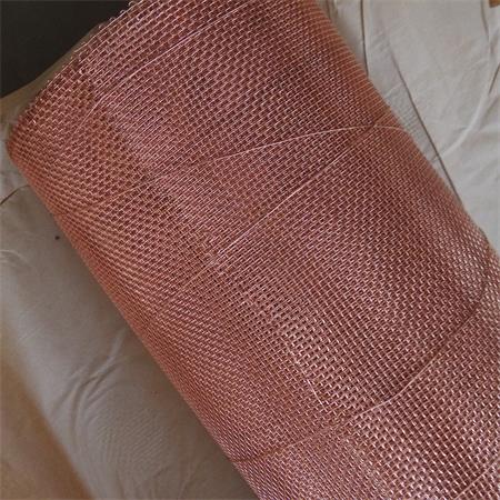 A roll of copper mesh with even structure on the brown paper.